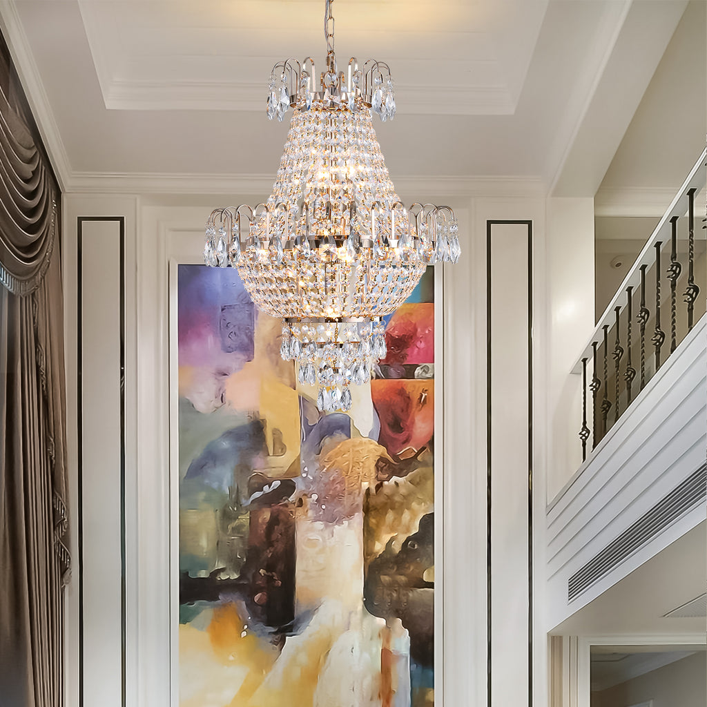 Crystal chandelier hanging in a room with a staircase and abstract painting on the wall.