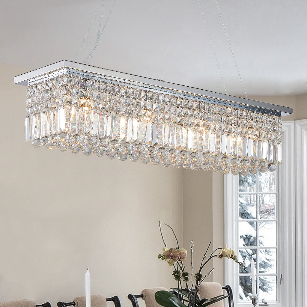 Crystal chandelier hanging in a room with a window and table.