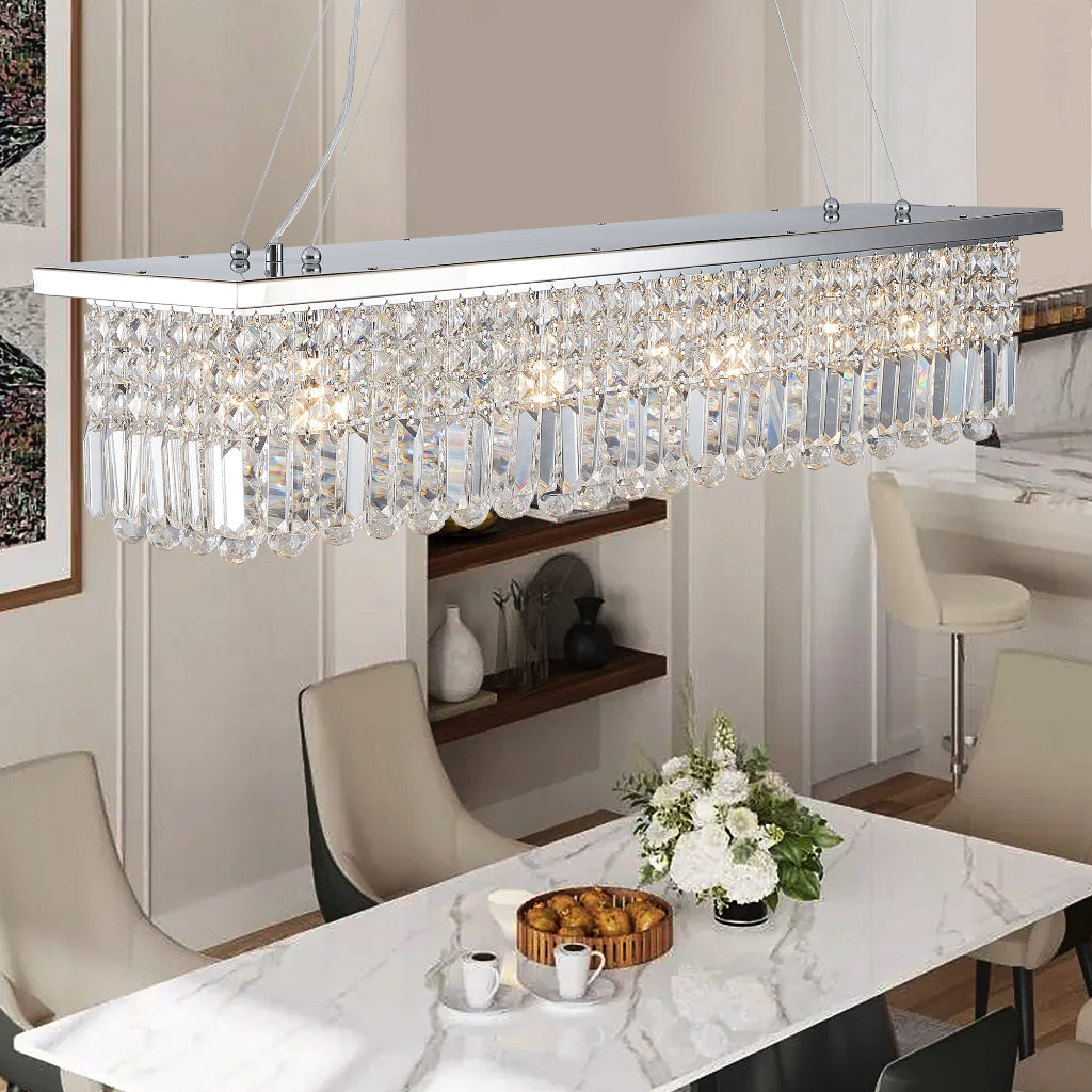 Modern dining room with a crystal chandelier, marble table, and chairs.