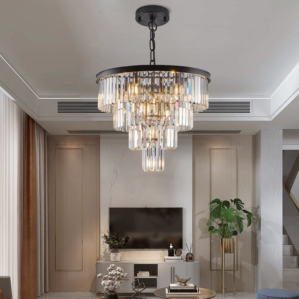 Chandelier hanging in a modern living room with a television and decorative plants.