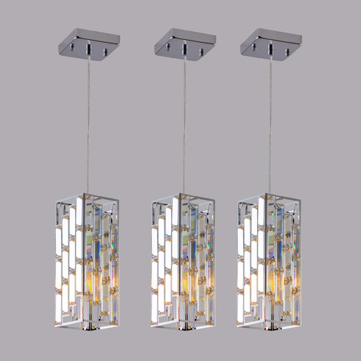 Three modern pendant lights with crystal accents on a gray background